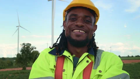 Portrait of smart engineer with protective helmet at electrical turbines fiel Stock Footage 269099626