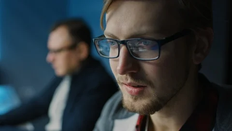 Portrait of a Smart Focused Young Man Wearing Glasses Working on a Desktop PC Stock Footage 103271085