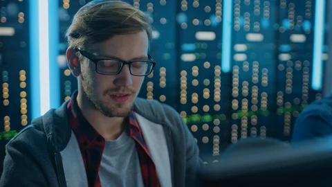 Portrait of a Smart Focused Young Man Wearing Glasses Working on a Desktop PC Stock Footage 103276191