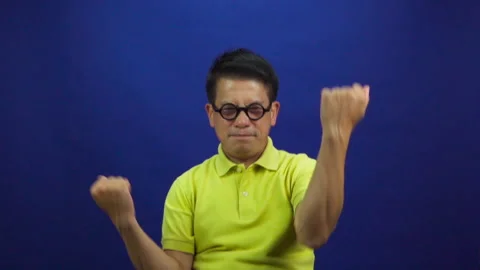 Portrait of smart middle-aged asian man in yellow T shirt feeling excited Stock Footage 219190096