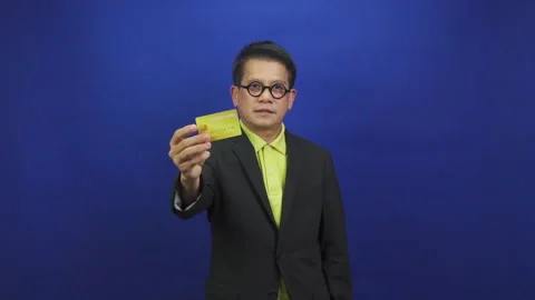 Portrait of smart middle-aged asian businessman wearing suit showing credit card Stock Footage 219190128