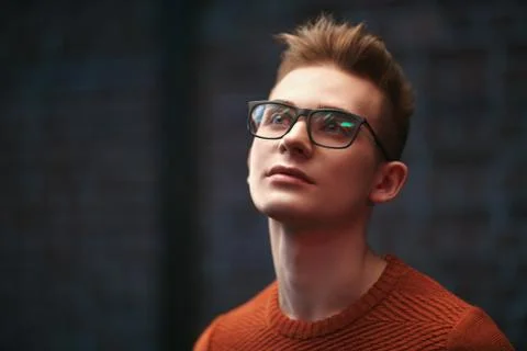 Portrait of a smart young guy in a pullover and glasses. Studio shot. Men's b Stock Photos