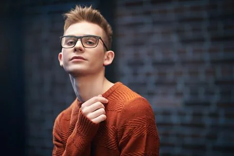 Portrait of a smart young guy in a pullover and glasses. Studio shot. Men's b Stock Photos