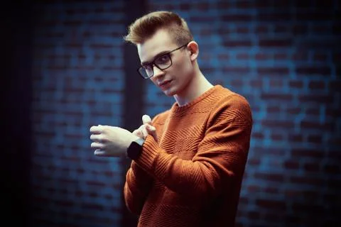 Portrait of a smart young guy in a pullover and glasses. Studio shot. Men's b Stock Photos
