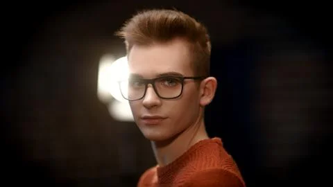 Portrait of a smart young guy in a pullover and glasses. Studio shot. Men's b Stock Photos