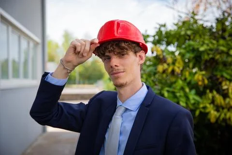 Portrait of a smartly dressed successful engineer holding protective helmet.. 库存照片