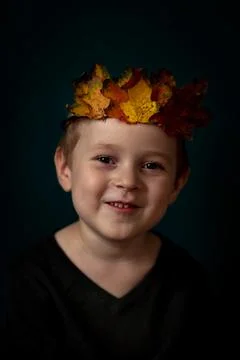 Portrait of a smiling 4-6 child with a crown of leaves on his head Stock Photos