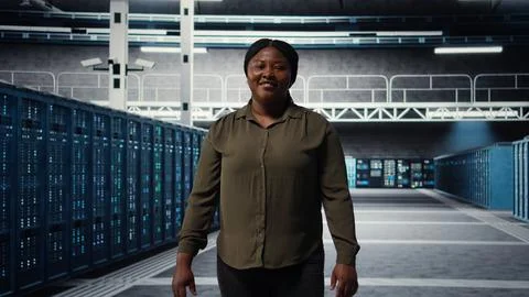 Portrait of smiling admin walking in data center, overseeing IT infrastructure Stock Photos