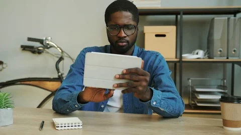 Portrait of smiling african business man in denim blue shirt using tablet for Stock Footage