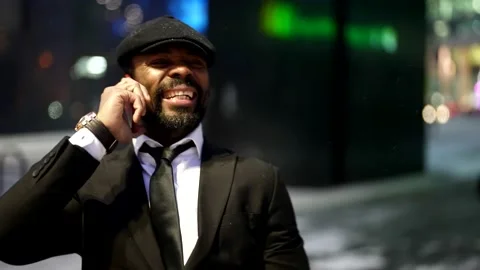 Portrait of smiling afro-american guy, calling by mobile phone on city street in Stock-Footage 168645545