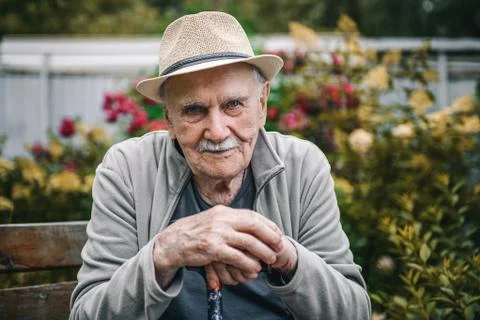 Portrait of a smiling and confident older 87-year-old handsome man in a hat with Stock Photos
