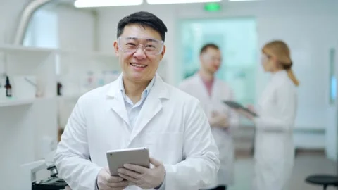 Portrait of smiling asian man scientist with protective glasses and gloves work Stock Footage 233309019