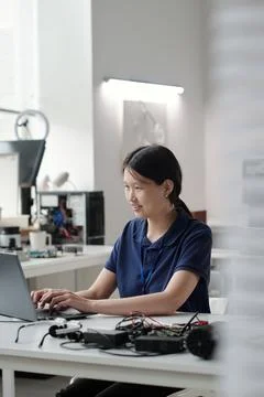 Portrait of Smiling Asian Woman Using Laptop in Modern Office Stock Photos