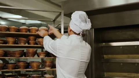 Portrait of smiling attractive worker in bakery shop with tasty golden bread in Stock Footage