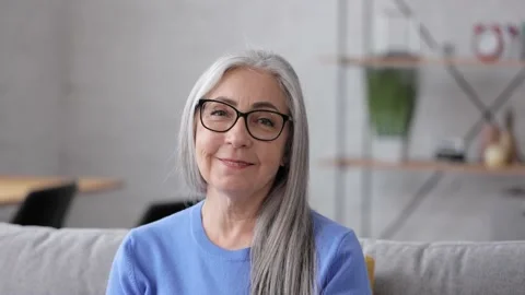 Portrait of smiling beautiful elderly gray-haired woman looking at camera Stock Footage 164532928