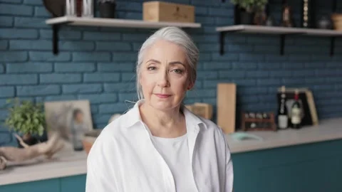 Portrait of smiling beautiful elderly gray-haired woman looking at camera Stock Footage 164762148