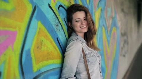 Portrait of smiling beautiful woman standing in front of graffiti Stock Footage