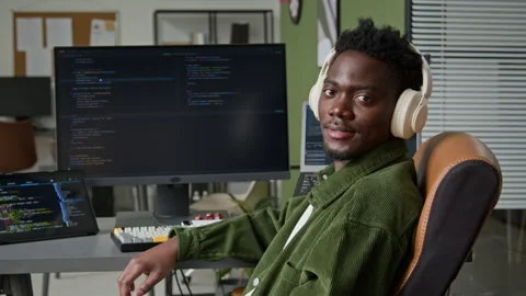 Portrait of Smiling Black Male Developer Using AI Vibe Coding Agent in Office Stock Footage 335940294