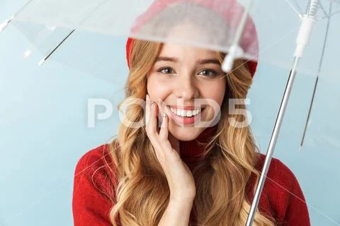 Portrait of smiling blond woman 20s with long hair standing under umbrella Stock Photos