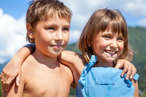 Portrait of a smiling boy and girl in a friendly embrace each other's shoulde Stock Photos