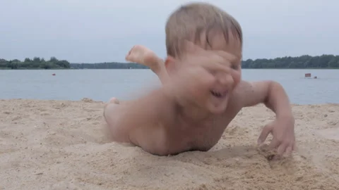 Portrait of smiling boy lying on the beach and playing with sand Stock-Footage 158315313
