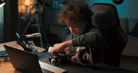 A portrait of a smiling boy, the talented intelligent student prepares a robot Stock Footage 200917820