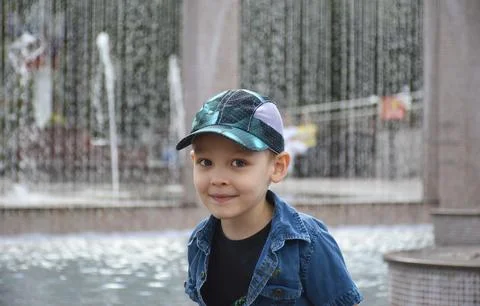 Portrait of a smiling boy while walking near a fountain Stock Photos