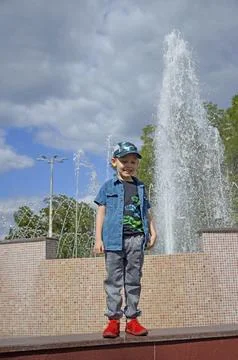 Portrait of a smiling boy while walking near a fountain Stock Photos