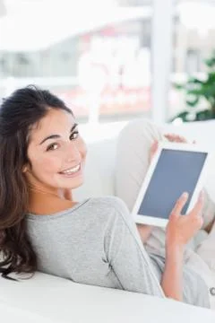 Portrait of a smiling brunette using a touchpad 写真素材