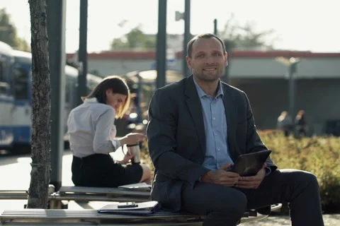Portrait of smiling businessman with tablet computer sitting on bench city NTSC Video stock 42128837