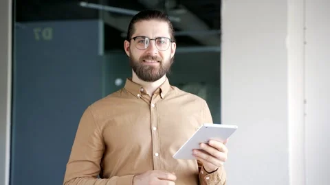 Portrait of smiling businessman using digital tablet standing at workplace  Stock Footage 321130311