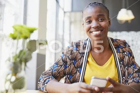 Portrait smiling businesswoman holding cell phone in cafe Stock Photos
