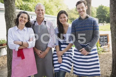 Portrait smiling cafe small business owners wearing aprons Stock Photos