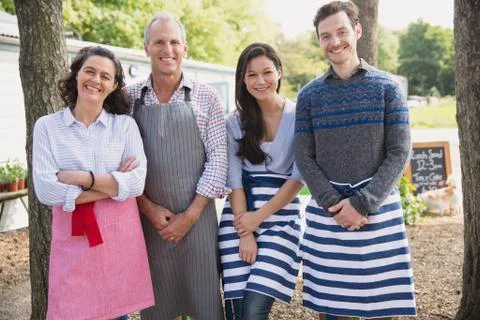 Portrait smiling cafe small business owners wearing aprons Stock Photos