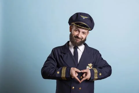 Portrait of smiling captain forms heart shape with hands Stock Photos