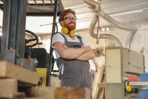 Portrait of smiling carpenter in eyeglasses standing on the background on Stock Photos