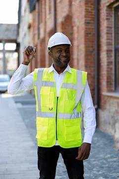Portrait of smiling construction engineer holding keys from new home. Happy Stock Photos