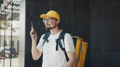 Portrait of smiling courier using cellphone. Contact a customer who is satisfied Stock Footage 172328263