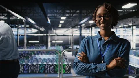 Portrait of smiling data center admin next to coworkers Stock Photos