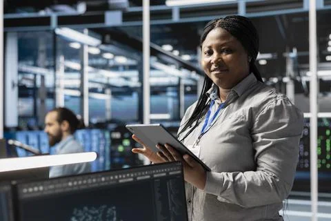 Portrait of smiling data center programmer using tablet to update servers tech 스톡 사진