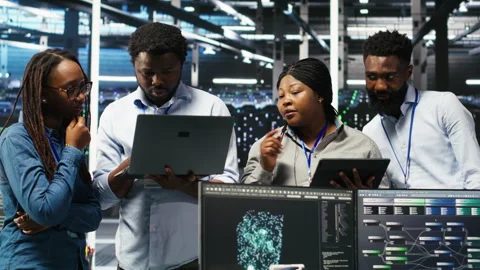 Portrait of smiling data center specialists collaborating in server facility Stock Footage 307024345