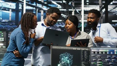 Portrait of smiling data center specialists collaborating in server facility Stock Photos