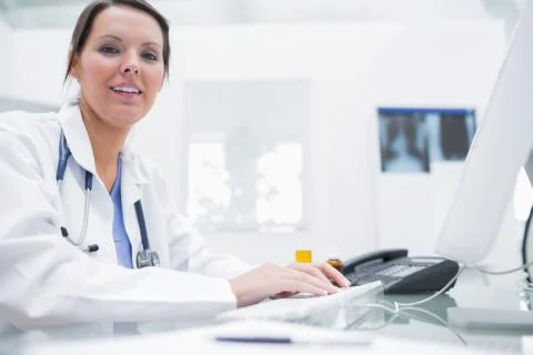 Portrait of smiling doctor using computer at clinic Foto stock
