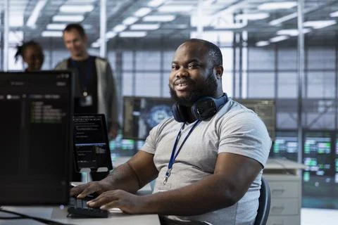 Portrait of smiling engineer in data center optimizing IT infrastructure Stock Photos
