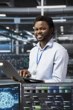 Portrait of smiling engineer in data center using artificial intelligence 스톡 사진