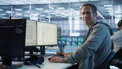 Portrait of smiling engineer inspecting server rows in data center 스톡 사진