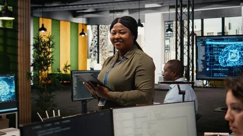 Portrait of smiling engineer working in office, using AI specialized hardware 스톡 사진