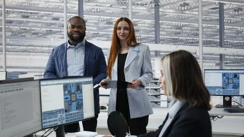 Portrait of smiling engineering team examining semiconductor substrate Stock Photos