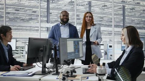 Portrait of smiling engineering team examining semiconductor substrate Stock Photos