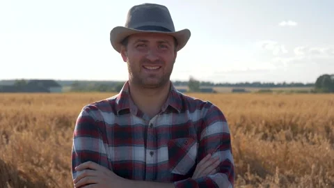 Portrait of smiling farmer standing in wheat field with arms crossed Video stock 308648681